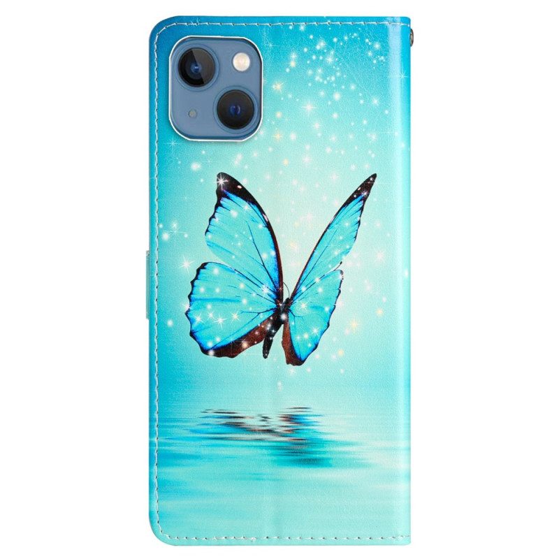 Custodia in pelle iPhone 15 Farfalla Blu In Volo Con Cinturino